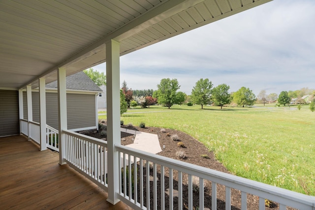 wooden deck featuring a lawn and covered porch
