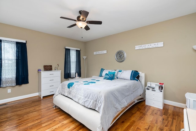 bedroom with baseboards, a ceiling fan, and wood finished floors
