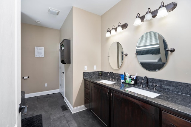 bathroom with double vanity, visible vents, and a sink