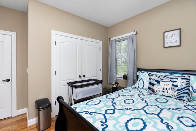 bedroom featuring a closet, baseboards, and light wood-style floors