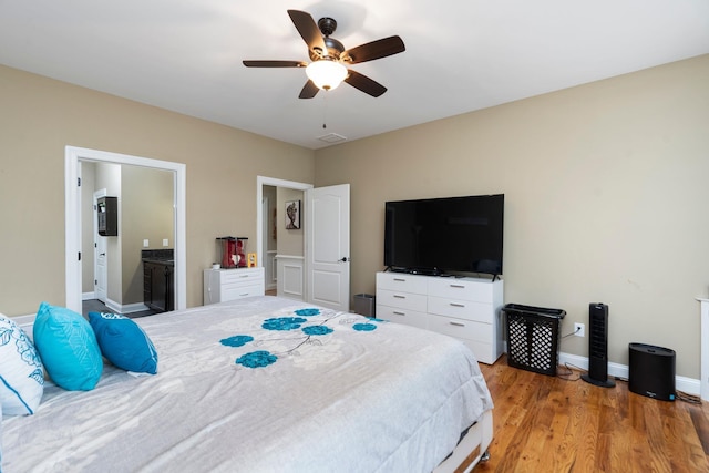 bedroom with visible vents, light wood-style floors, baseboards, connected bathroom, and a ceiling fan