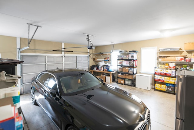 garage featuring freestanding refrigerator, fridge, and a garage door opener