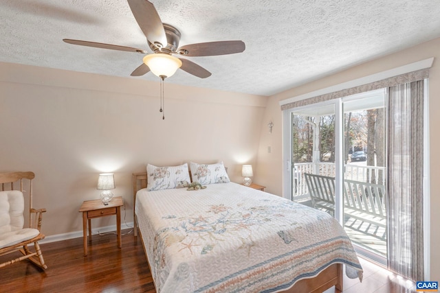 bedroom with a textured ceiling, access to outside, dark wood-style flooring, and baseboards