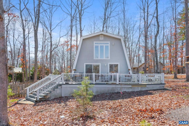 rear view of house with fence, a deck, a gambrel roof, and stairs