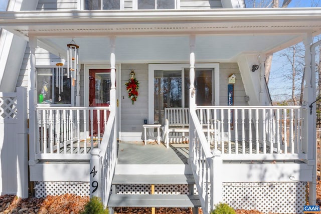 view of exterior entry featuring covered porch