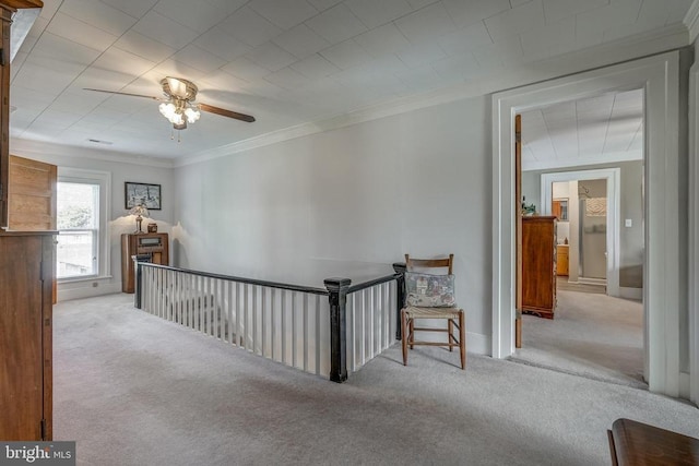 hallway with carpet floors, an upstairs landing, and ornamental molding