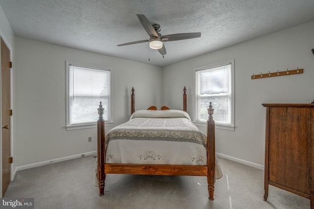 bedroom featuring baseboards, carpet floors, a textured ceiling, and ceiling fan