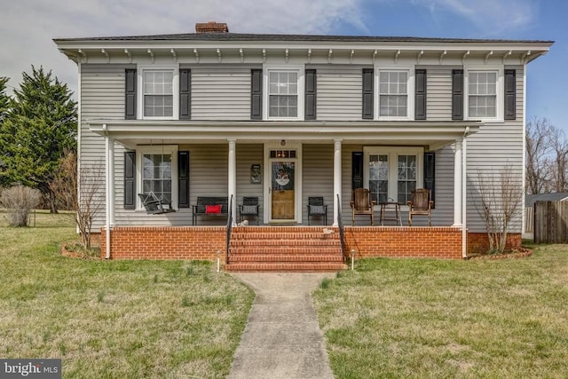 italianate-style house with a front lawn, covered porch, and a chimney