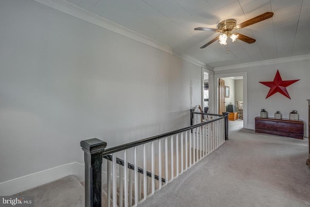 hall with an upstairs landing, carpet floors, and ornamental molding