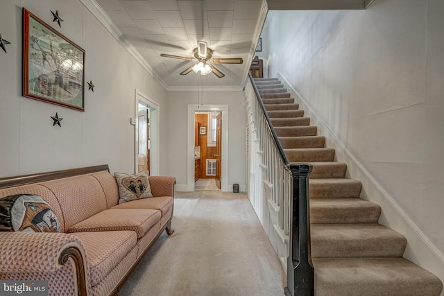 living room with stairs, ornamental molding, a ceiling fan, and light carpet