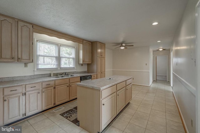 kitchen with light tile patterned floors, light brown cabinets, a kitchen island, a sink, and light countertops