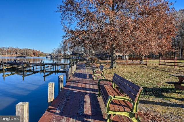 view of dock featuring a water view and fence