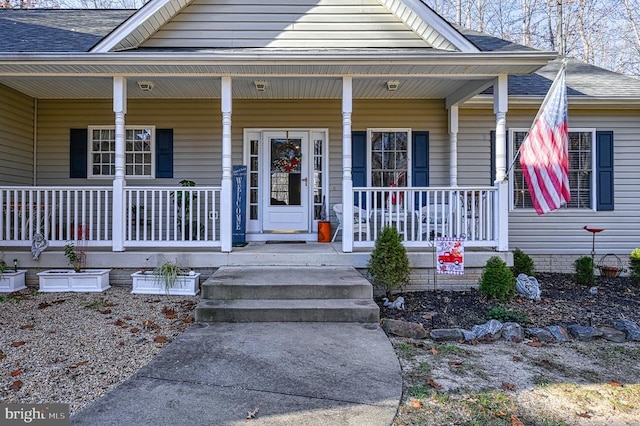 bungalow-style home with covered porch and a shingled roof