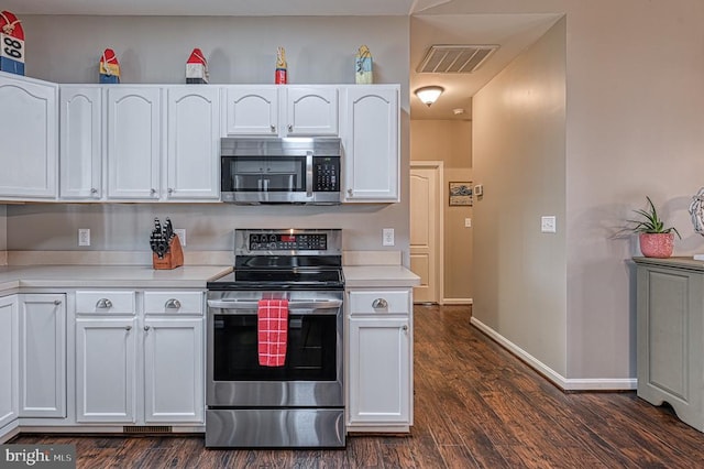 kitchen with stainless steel appliances, light countertops, visible vents, dark wood-type flooring, and white cabinetry