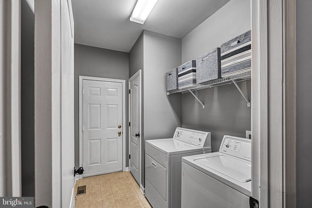 clothes washing area featuring laundry area, visible vents, washer and clothes dryer, and light floors