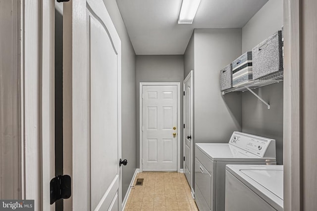 clothes washing area featuring laundry area, visible vents, baseboards, and washing machine and clothes dryer