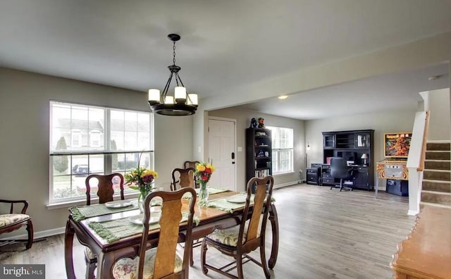 dining area with stairway, baseboards, light wood-style floors, and a chandelier