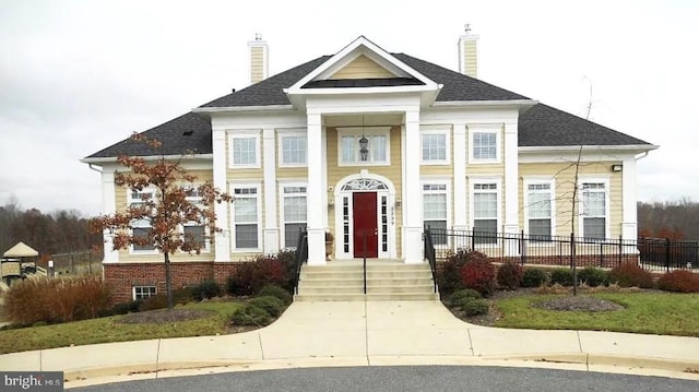 greek revival inspired property featuring fence and a chimney