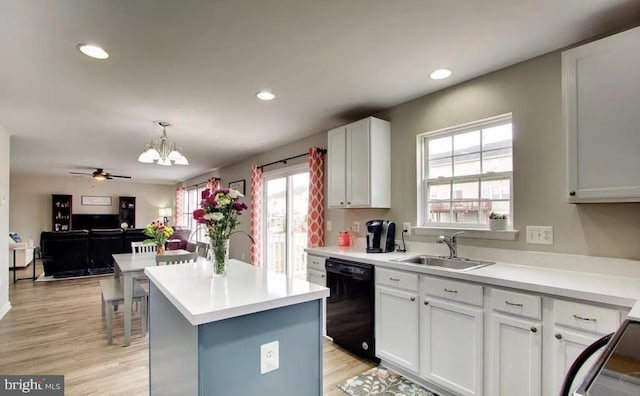 kitchen featuring a kitchen island, light wood-type flooring, black dishwasher, white cabinets, and a sink