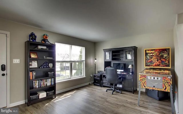 home office with baseboards and wood finished floors