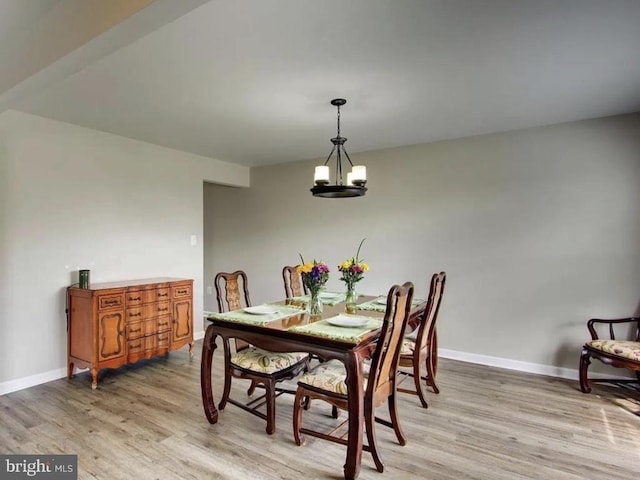 dining room featuring baseboards, a chandelier, and light wood finished floors