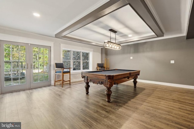 playroom with wood finished floors, a raised ceiling, and crown molding