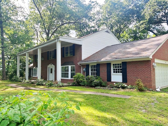 view of front of home with a front lawn, brick siding, and an attached garage