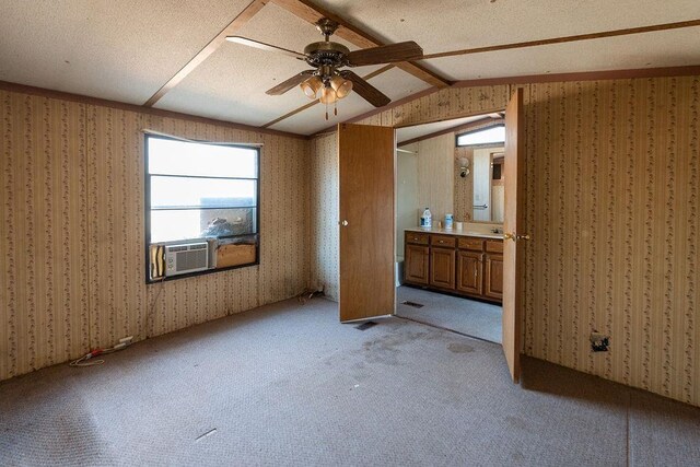 unfurnished bedroom featuring lofted ceiling, light colored carpet, ensuite bath, and wallpapered walls