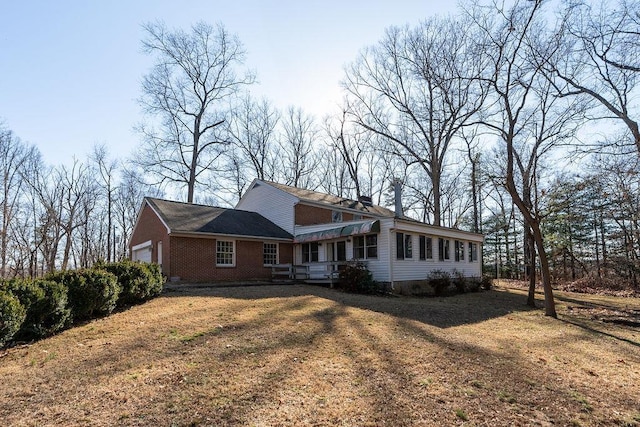 view of front of home with brick siding, an attached garage, and a front yard