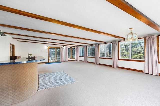 unfurnished living room featuring beam ceiling, carpet flooring, and baseboards