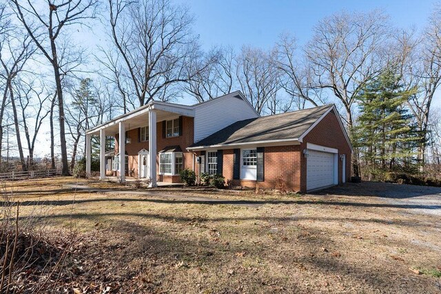 greek revival house featuring an attached garage, driveway, brick siding, and a porch