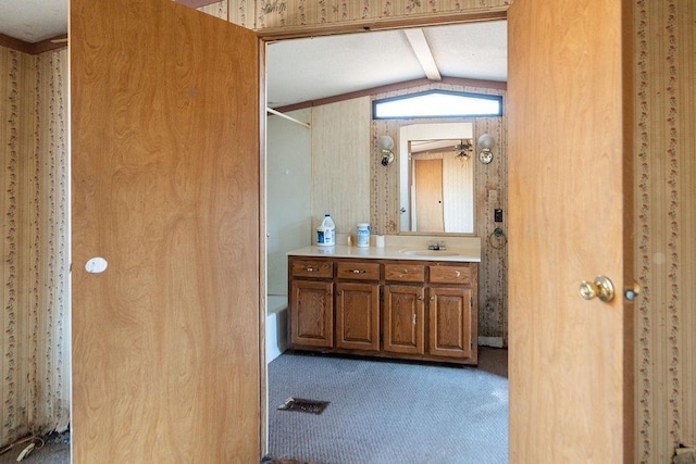 full bathroom featuring lofted ceiling with beams, walk in shower, and vanity