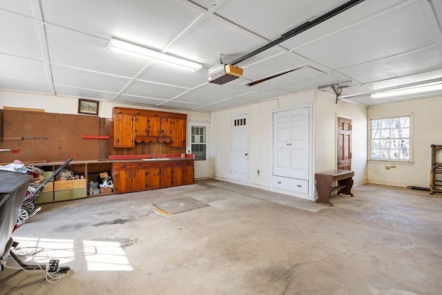 garage with a garage door opener, a sink, and a workshop area