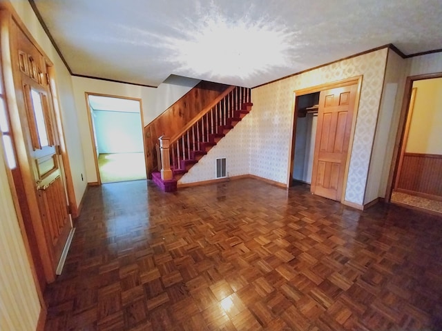 interior space featuring crown molding, visible vents, wallpapered walls, wainscoting, and stairs