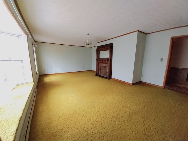 carpeted empty room with baseboards, ornamental molding, a brick fireplace, and a notable chandelier