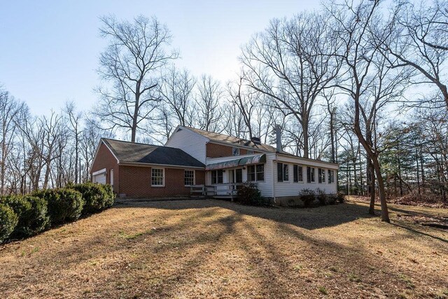 view of front of property featuring a garage, brick siding, and a front yard