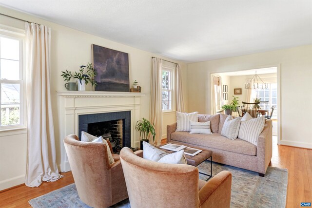 living room with plenty of natural light, wood finished floors, and a fireplace with flush hearth