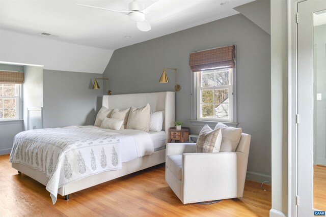 bedroom featuring multiple windows, vaulted ceiling, and light wood finished floors