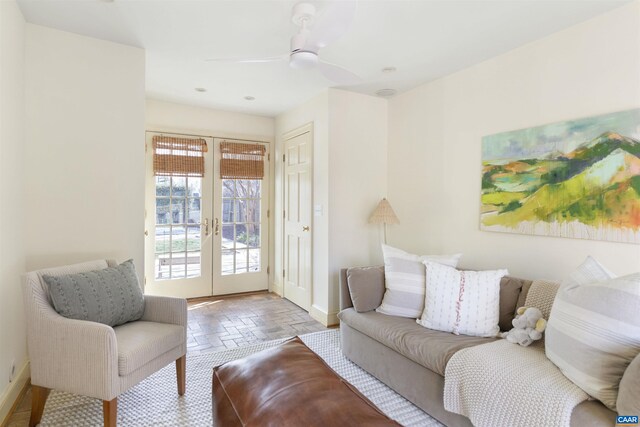 living area featuring french doors, a ceiling fan, and baseboards