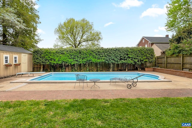 view of pool featuring a fenced in pool, a fenced backyard, a patio area, an outbuilding, and a diving board