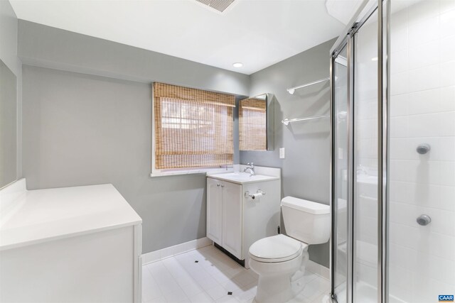 bathroom featuring visible vents, toilet, a shower stall, baseboards, and vanity