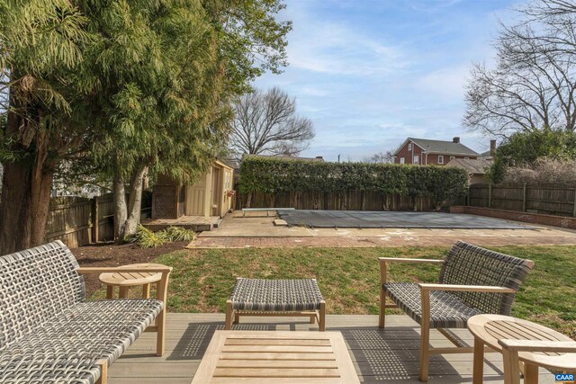 view of yard featuring a shed, an outdoor structure, a fenced backyard, and a deck