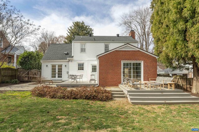 back of house with french doors, a lawn, a chimney, and fence