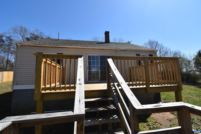 snow covered rear of property with central AC unit and a deck