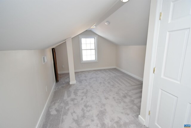 bonus room with lofted ceiling and light carpet