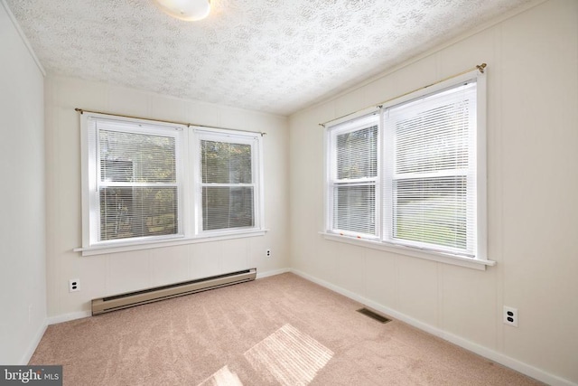 empty room featuring light colored carpet, a textured ceiling, and baseboard heating