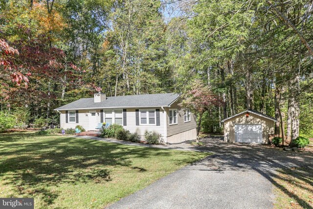 ranch-style home with a garage, an outdoor structure, and a front lawn