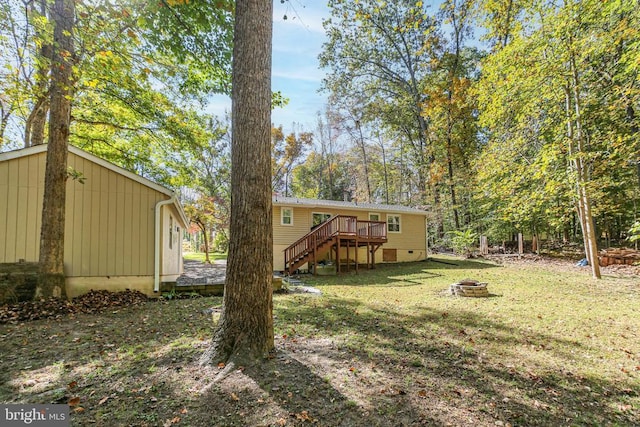 view of yard with a wooden deck and a fire pit