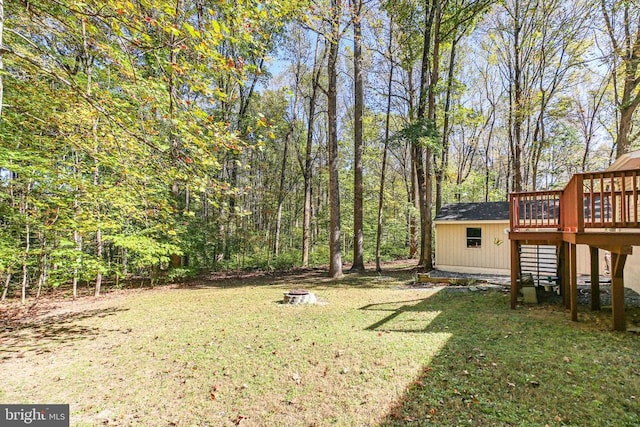 view of yard with a wooden deck and a fire pit