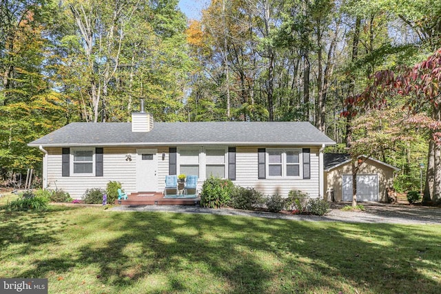 view of front facade featuring a garage, an outdoor structure, and a front yard